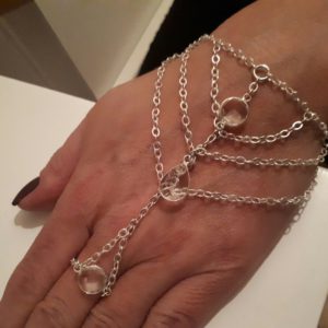 Silverfärgat handsmycke med glasklara detaljer