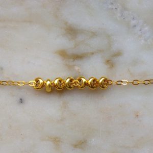 Guldfärgat armband med guldfärgade detaljer
