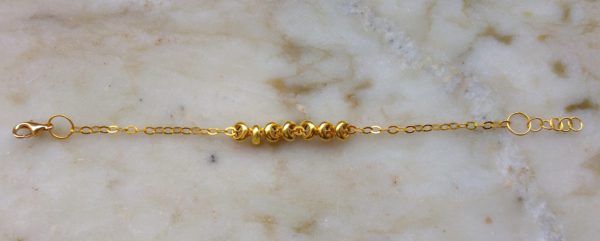 Guldfärgat armband med guldfärgade detaljer