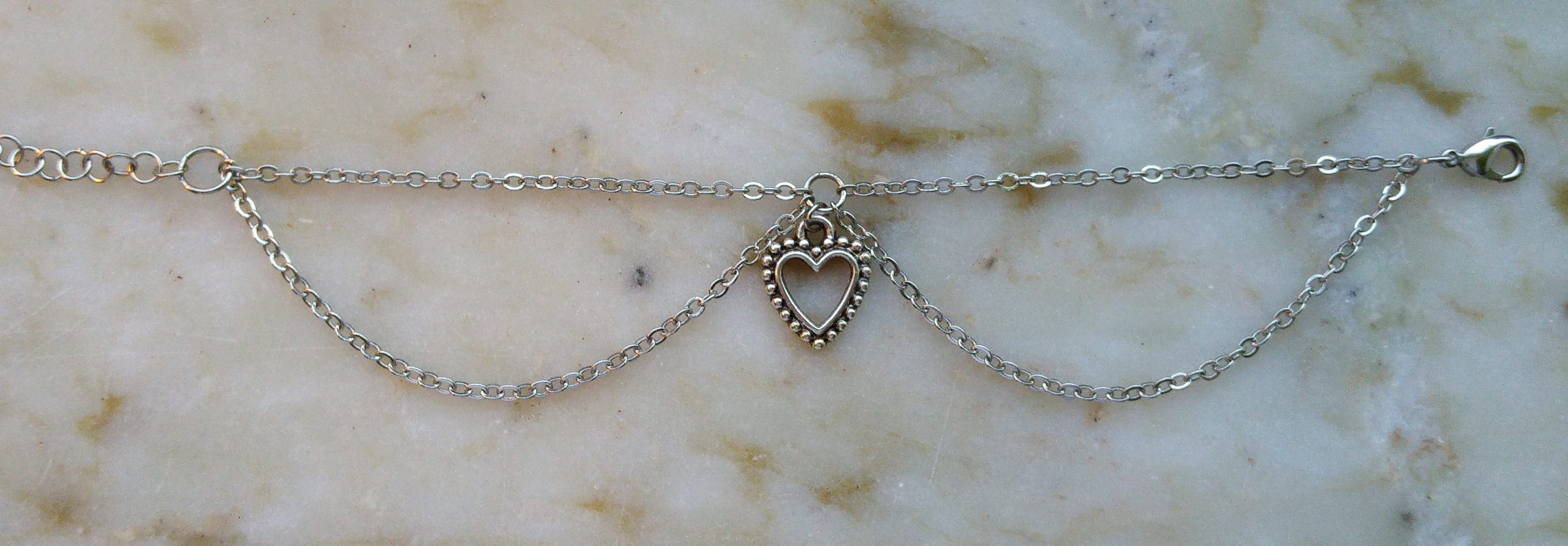 Silverfärgat armband med ett silverfärgat hjärta