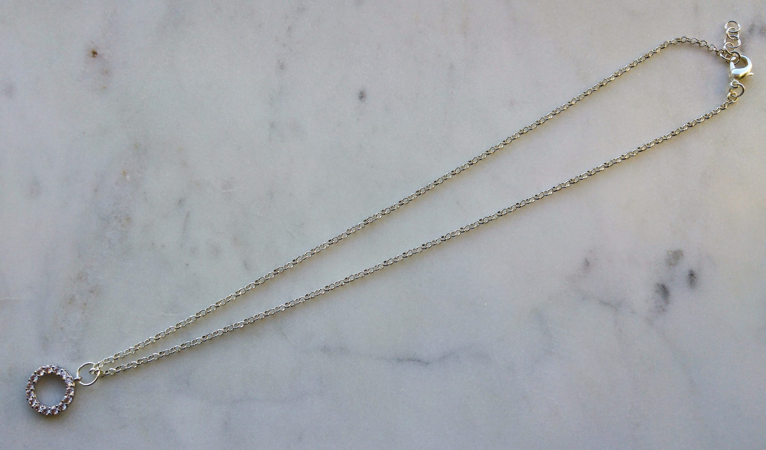 Halsband med silverfärgad metallkedja och en strassberlock (kubisk zirkonia) av hög kvalitet.