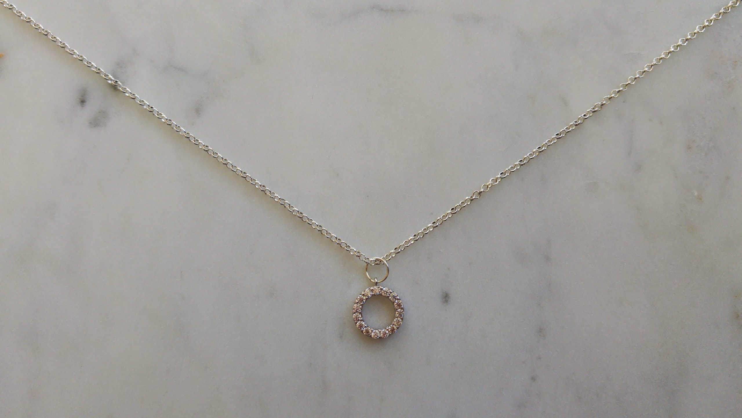 Halsband med silverfärgad metallkedja och en strassberlock (kubisk zirkonia) av hög kvalitet.