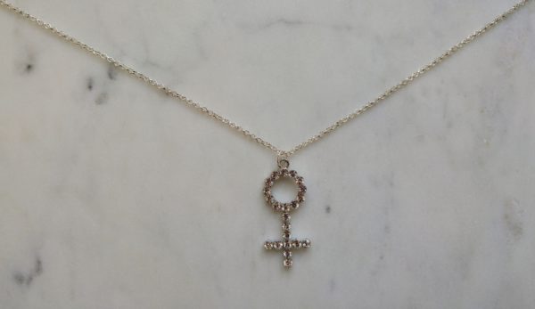 Silverfärgat halsband med en venussymbol i strass