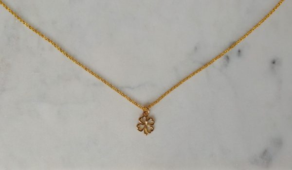 Guldfärgat halsband med en fyrklöver.