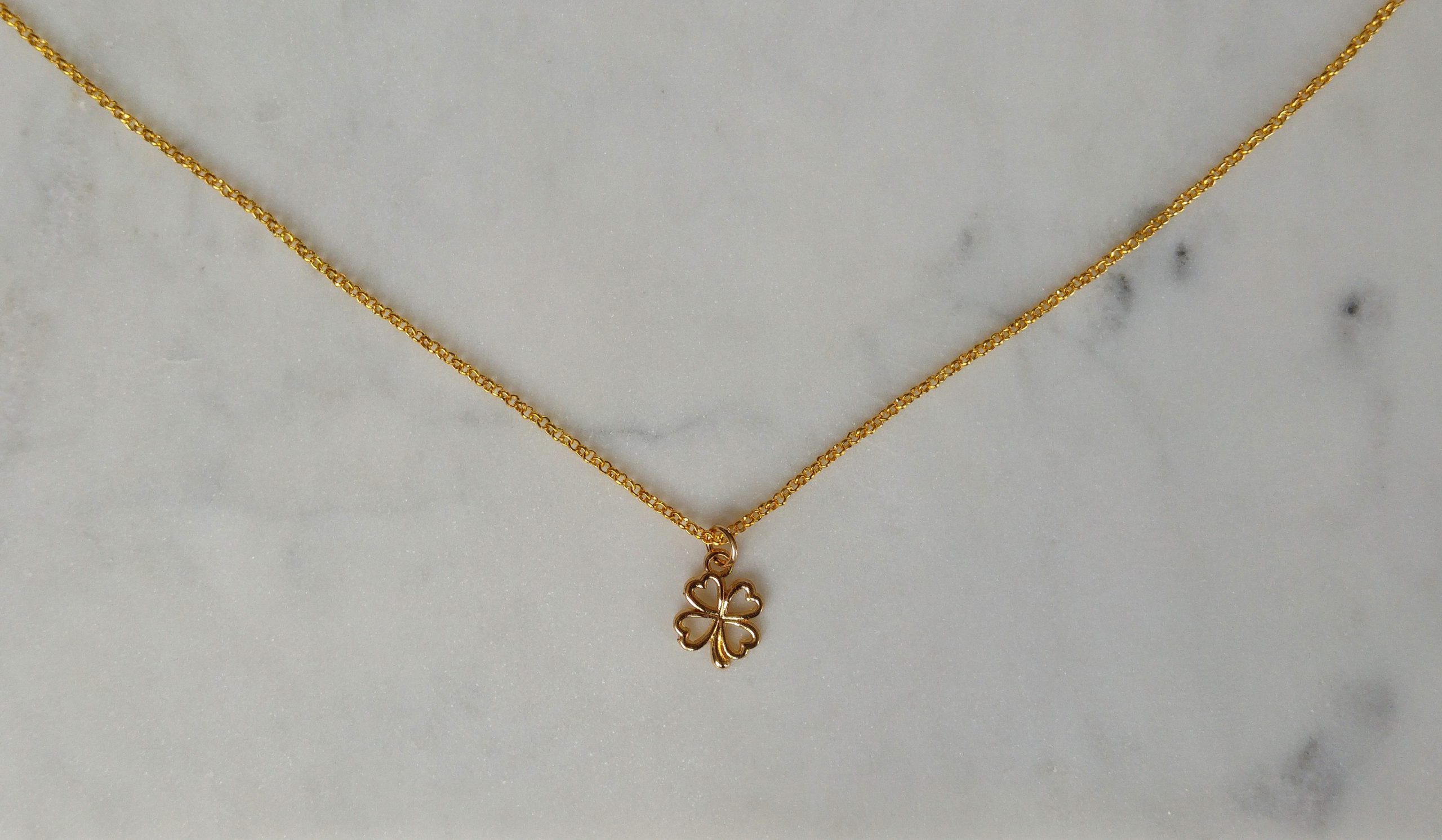 Guldfärgat halsband med en fyrklöver.