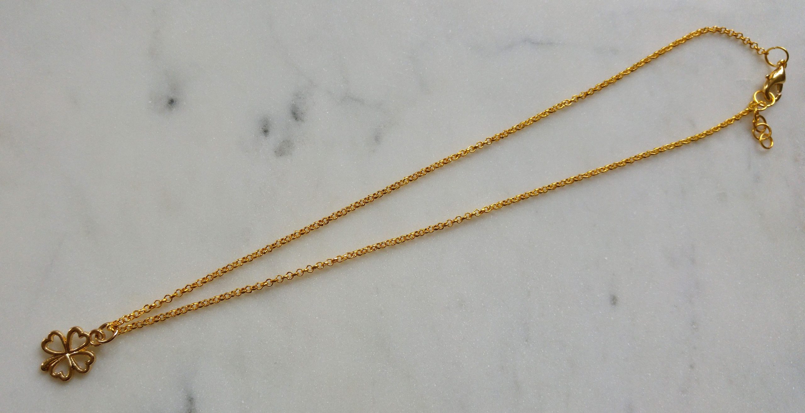 Guldfärgat halsband med en fyrklöver.