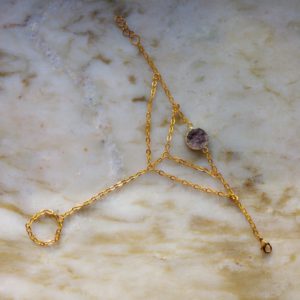 Guldfärgat handsmycke med en grålila druzy agat