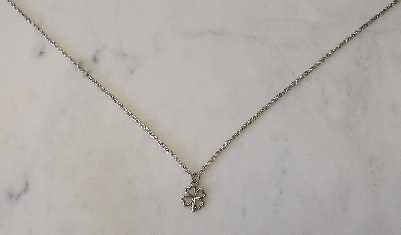 Halsband med antiksilverfärgad metallkedja och en antiksilverfärgad fyrklöver.