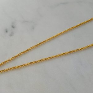 Guldfärgat halsband med en vit snäcka
