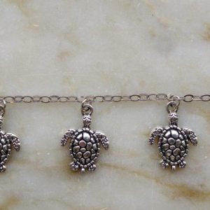 Antiksilverfärgad metallkedja med sköldpaddor
