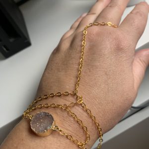 Guldfärgat handsmycke med en rosa druzy agat