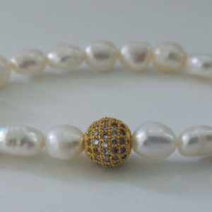 Elastiskt armband med sötvattenpärlor och guldfärgade strassdetaljer
