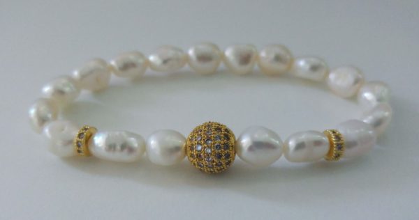 Elastiskt armband med äkta sötvattenpärlor, guldfärgad stor strasspärla och guldfärgade strassrondeller (kubisk zirkonia). 